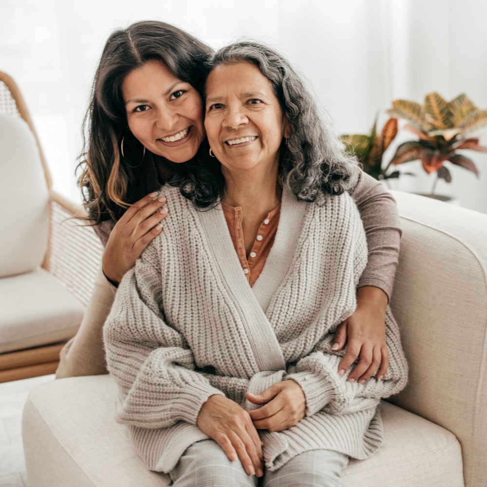 a mother and daughter sit on a couch
